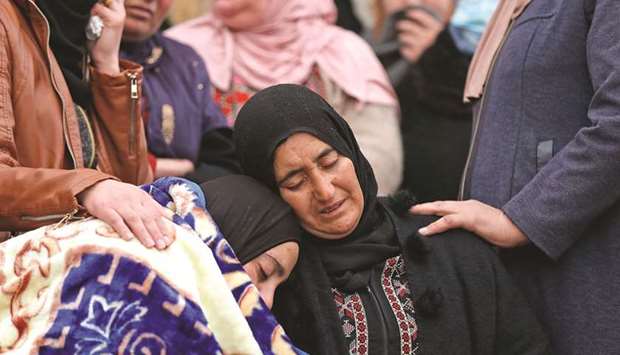 The mother and sister of Palestinian teenager Ali Abu Aliya mourn during his funeral in the village of Mughayir near Ramallah in the occupied West Bank, yesterday.