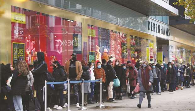 Shoppers queue outside Debenhams on Oxford Street in London yesterday. Shoppers returned to Englandu2019s high streets this week as shops reopened following the end of a four-week coronavirus lockdown.