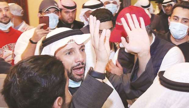 Kuwaiti candidate and former parliament speaker Marzouq al-Ghanem celebrates with his supporters following the announcement of his victory in the parliamentary election in Kuwait City, yesterday.
