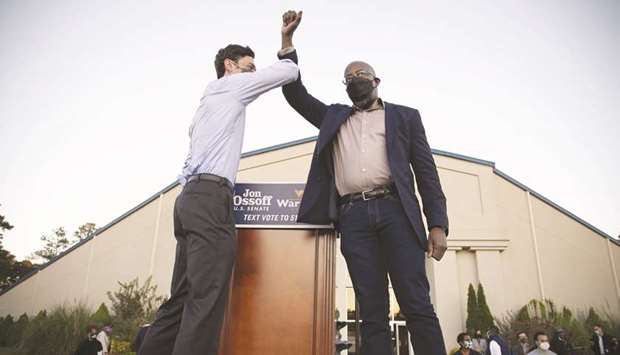 IN THE FRAY: Democratic candidates Jon Ossoff, left, and Raphael Warnock bump elbows on stage at a rally in Jonesboro, Georgia, last month.