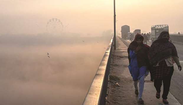 People make their way amid heavy smoggy conditions in Lahore.  (AFP)
