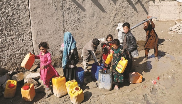 STRUGGLING: Internally displaced Afghans collect water from a public water pump next to their tents at a refugee camp in Kabul. (Reuters file photo)