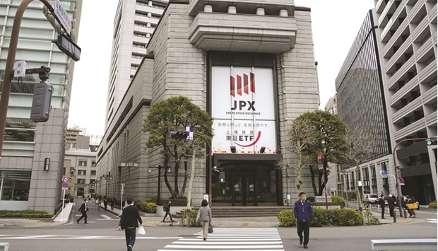 Pedestrians walk by the Tokyo Stock Exchange building. The Nikkei 225 closed up 2.1% to 26,717.34 points yesterday.