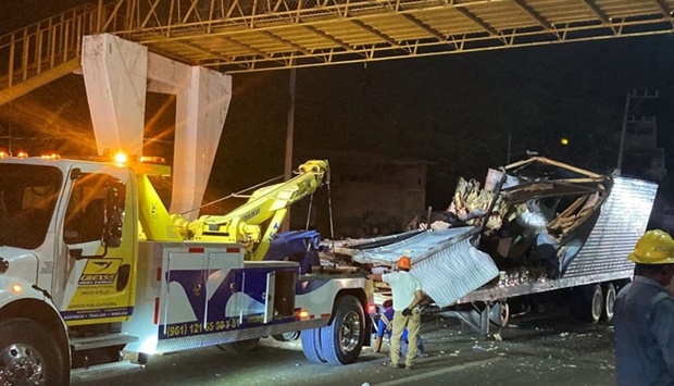 Workers remove the container from the trailer of a truck that crashed with migrants aboard during a road accident in Tuxtla Gutierrez, Chiapas state, Mexico, on December 9.