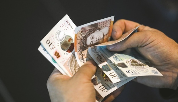 A man holds pound sterling banknotes in an arranged photograph in London. Thereu2019s trouble brewing for the pound as the UK tightens its coronavirus restrictions once again.