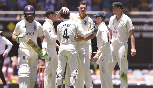 Australiau2019s Josh Hazlewood celebrates the wicket of Englandu2019s Jos Buttler (left) with teammates on the fourth day of the first Ashes Test against England at the Gabba, Brisbane, Australia, yesterday. (Reuters)