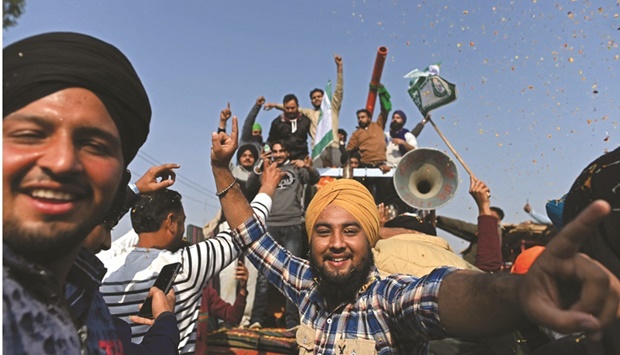 Farmers cheer as they leave the protesting site at Delhi-Haryana state border in Singhu yesterday. (AFP)