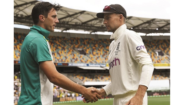 Australiau2019s Pat Cummins (left) shakes hands with Englandu2019s Joe Root after the first Ashes Test at the Gabba in Brisbane, Australia, on Saturday. Australia won the Test by nine wickets. (Reuters)