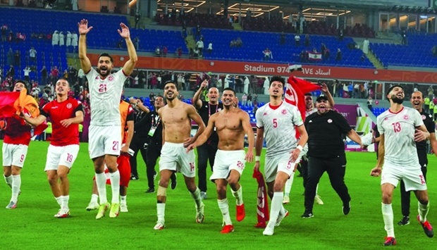 Tunisia's players celebrate winning the FIFA Arab Cup 2021 semi-final football match between Tunisia and Egypt at the 974 stadium