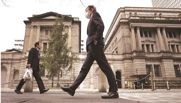 Pedestrians walk past the Bank of Japan headquarters in Tokyo.