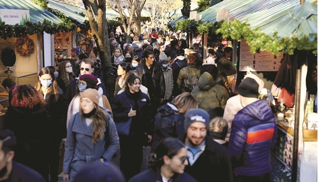 Shoppers walk through the Urbanspace Union Square Holiday Market in New York. The US economy is on track for a strong finish to 2021 and a solid start to 2022 as consumers and businesses keep spending despite high inflation, staffing challenges, persistent Covid-19 infections and lingering supply constraints.