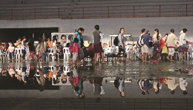 Residents take shelter in a cultural centre turned into an evacuation centre after Super Typhoon Rai passed in Isabela town of the Philippinesu2019 Negros Occidental province.