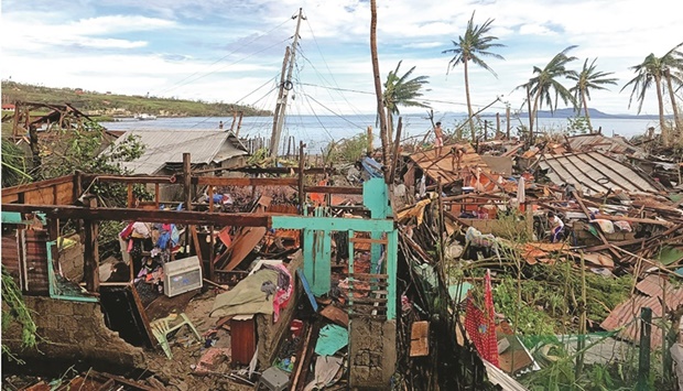 Residents standing by their houses destroyed by Super Typhoon Rai after the storm crossed over Surigao City in Surigao del Norte province. (AFP)