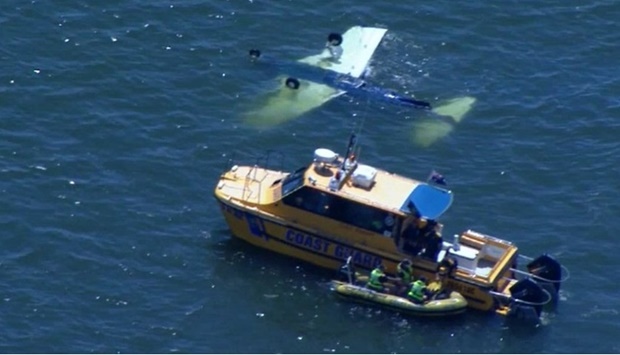 The coastguard at the scene of the semi-submerged plane on Sunday. Picture courtesy of Brisbane Times