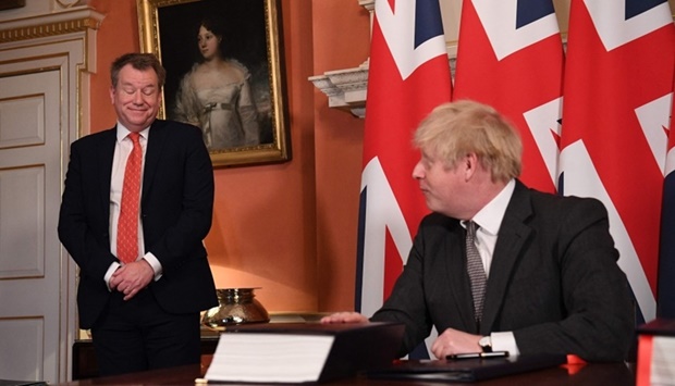 UK chief trade negotiator, David Frost (L) looks on as Britain's Prime Minister Boris Johnson (L) signs the Trade and Cooperation Agreement between the UK and the EU, the Brexit trade deal on December 30, 2020 at 10 Downing Street in central London