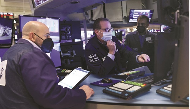 Traders wearing face masks work on the trading floor at the New York Stock Exchange yesterday. Just as investors were wrapping up this yearu2019s trading, the threat of new lockdowns sent shock waves through markets across the world.
