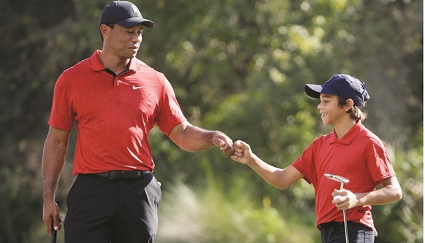 Tiger Woods and Charlie Woods celebrate a birdie on the 12th hole during the final round of the PNC Championship at the Ritz-Carlton Golf Club Grande Lakes in Orlando, Florida. (AFP)