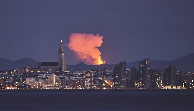 This photo taken on May 5 shows the Reykjavik skyline with the glow from lava coming out of a fissure near the Fagradalsfjall, on the Reykjanes Peninsula. After three months of interruption, the eruption of the volcano near Reykjavik is considered officially over, authorities said yesterday.