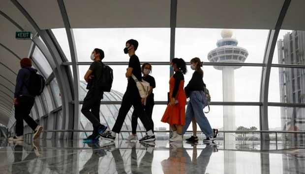 People pass the control tower of Singapore's Changi Airport, Singapore.