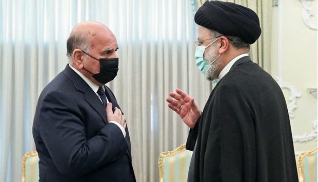 Iranian President Ebrahim Raisi greeting Iraqu2019s Foreign Minister Fuad Hussein in Tehran.