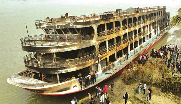 The burnt passenger ferry is seen anchored on the bank of Sugandha River in Jhalalathi, Bangladesh, yesterday.