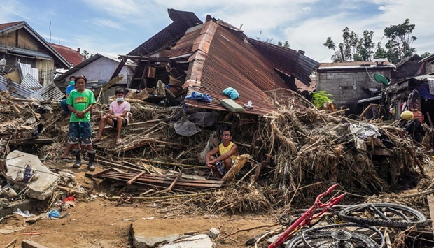 Residents gather next to a destroyed house in Bais city, Negros Oriental, days after Super Typhoon Rai hit the southern and central regions of the archipelago.