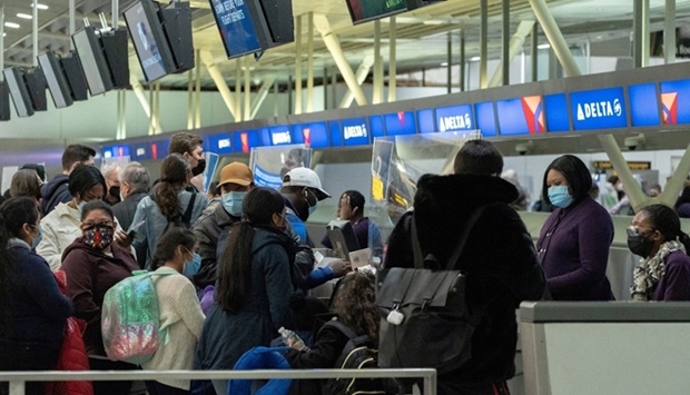 Travelers check in at John F. Kennedy International Airport during the spread of the Omicron coronavirus variant in Queens, New York City yesterday. REUTERS
