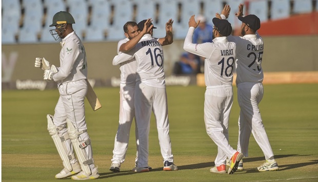 South Africau2019s Kagiso Rabada (left) walks back to the pavilion after his dismissal by Indiau2019s Mohamed Shami (second from left) during the third day of the first Test at the SuperSport Park in Centurion yesterday. (AFP)