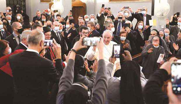 This photo taken by the Vatican Media shows people taking pictures of Pope Francis as he enters the Maronite Lady of Grace cathedral in Nicosia.