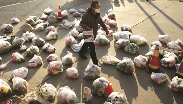 A worker prepares food supplies to be delivered to residents of a residential compound under lockdown, in Xian, Shaanxi province, China.