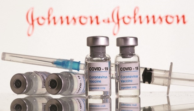 File photo of vials labelled u201cCovid-19 Coronavirus Vaccineu201d and syringe are seen in front of a Johnson & Johnson logo.