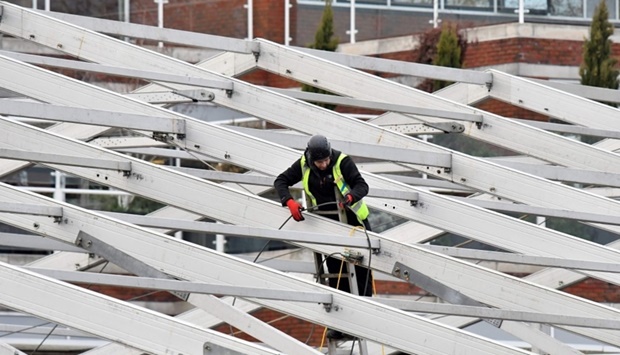 A member of a construction team works on the erection of a temporary field hospital in the grounds of St George's Hospital in Tooting, south London on December 30, as the number of daily Covid-19 cases has increased, fuelled by the highly contagious Omicron variant