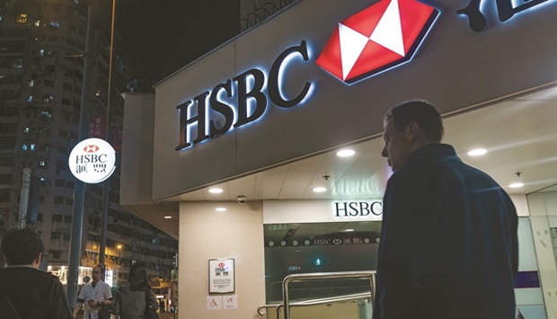 Pedestrians walk past an HSBC Holdings bank branch at night in Hong Kong. HSBC won regulatory approval to take full control of its life insurance venture in China after more than one and half yearsu2019 waiting, marking an initial success in mending frayed relations with Beijing.