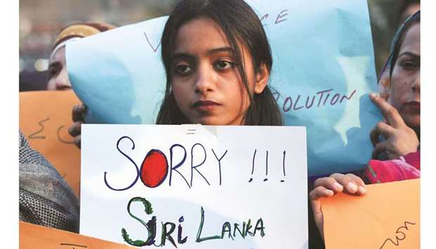 A girl carries a sign, condemning the lynching of the Sri Lankan manager of a garment factory after an attack on the factory in Sialkot, during a protest in Lahore yesterday. (Reuters)