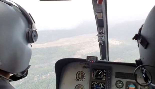 Officials on a helicopter inspect an area impacted by the eruption of Semeru volcano, in East Java Province, Indonesia, in this still image obtained from video. Courtesy of Thoriqul Haq / Social Media via REUTERS