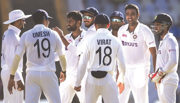 Indiau2019s Ravichandran Ashwin (second right) celebrates with his teammates after taking the wicket of New Zealandu2019s Ross Taylor (not pictured) during the third day of the second Test match at the Wankhede Stadium in Mumbai yesterday. (AFP)
