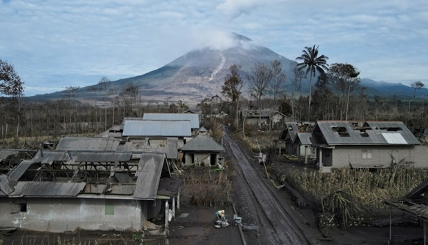 A local collects usable goods from her damaged house, at an area affected by the eruption of Mount Semeru volcano, in Curah Kobokan, Pronojiwo district, Lumajang, Indonesia. REUTERS