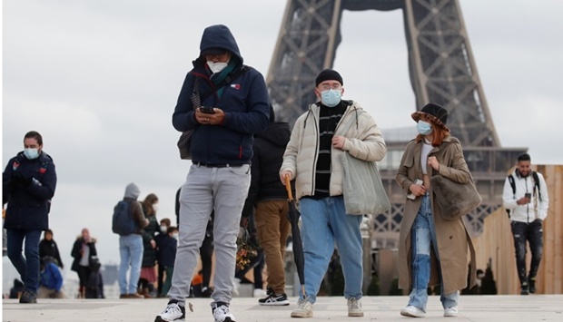 People, wearing protective face masks, walk on Trocadero square near the Eiffel Tower in Paris amid the coronavirus disease outbreak in France. REUTERS