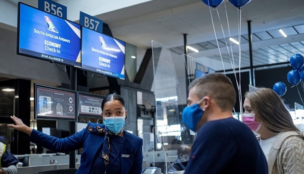 A South African Airways employee directs passengers at the OR Tambo International Airport in Johannesburg. Amid concerns about new Omicron variantu2019s impact on the aviation industry, and a series of unilateral knee-jerk reactions from governments around the world, global airline capacity seems to remain stable.