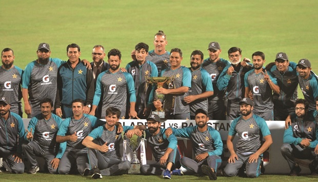 Pakistanu2019s players pose with the trophy after winning the the second Test match against Bangladesh at the Sher-e-Bangla National Cricket Stadium in Dhaka yesterday. (AFP)