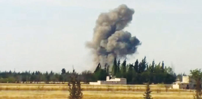 An image grab taken from a video uploaded on YouTube shows smoke billowing from buildings in the city of Qusayr, in Syriau2019s central Homs province, fol