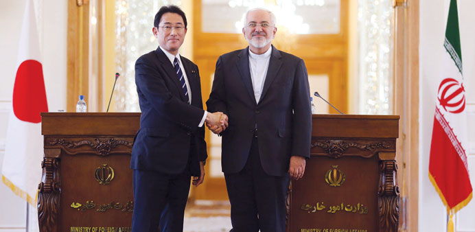 Zarif shakes hands with Kishida following their press conference in Tehran yesterday.