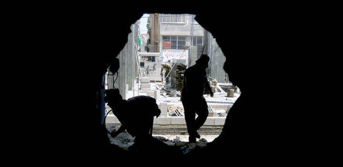 Workers rebuild yesterday a house in Gaza City in which Mohamed al-Dallu was killed along with nine members of his family and two neighbours during Is