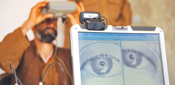An Afghan policeman looks into a biometric eye scanner.