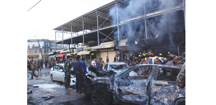 People gather at the scene of the blast in Arbil yesterday.