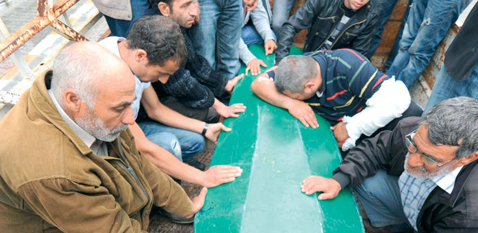 People mourn beside the coffin of 18-year-old Ogulcan Tuna yesterday during the funerals of victims of  Saturdayu2019s car bombings at Reyhanli.