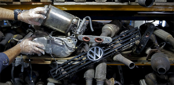 A worker shows exhaust systems for Volkswagen vehicles 