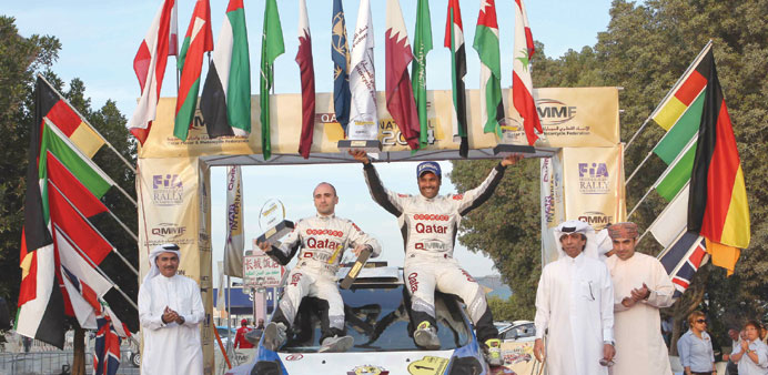 Qatar's Nasser Saleh al-Attiyah and Giovanni Bernacchini celebrate on the podium after winning the 2014 QatarInternational Rally yesterday.
