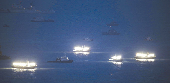 Fishing boats emit light during a night rescue operation at an area where the capsized passenger ship Sewol sank, at the sea off Jindo yesterday. 
