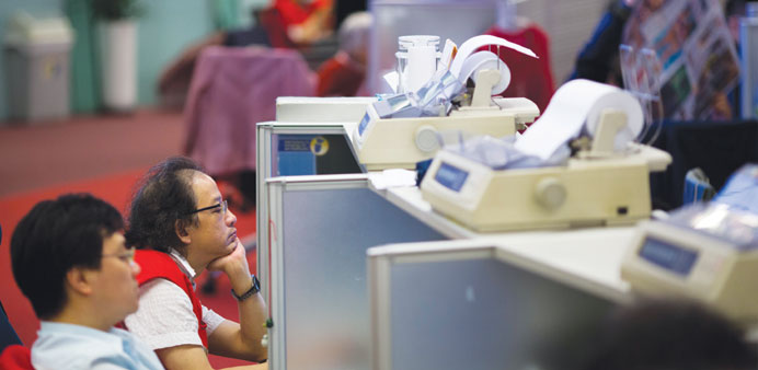 Traders work at their desks on the floor of the Hong Kong Stock Exchange. The Hong Kong index climbed 1.47%, or 337.13 points, to 23,252.41 in yesterd